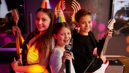 Kids at a party playing with musical instruments